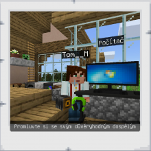 Na obrázku je postava ze hry Minecraft, která stojí u počítače